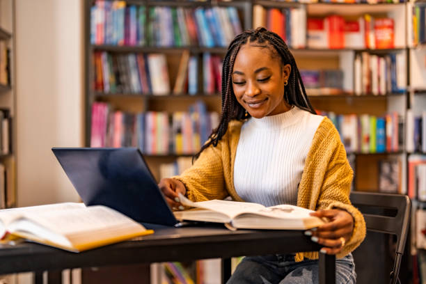 Attractive young female university student using a laptop while studying